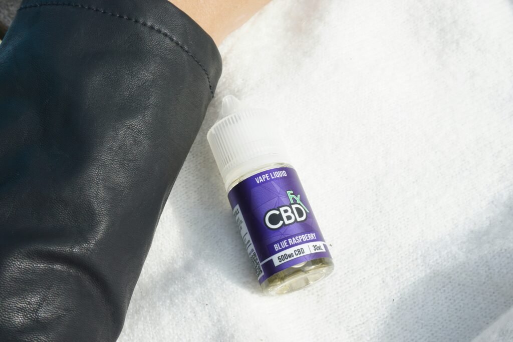 a close-up of a bottle of cbd vape liquid, labeled 'Blue raspberry